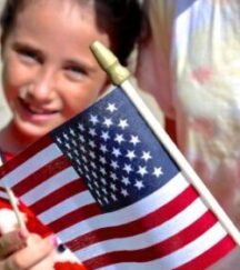 Military child at Veterans Day Parade with American Flag