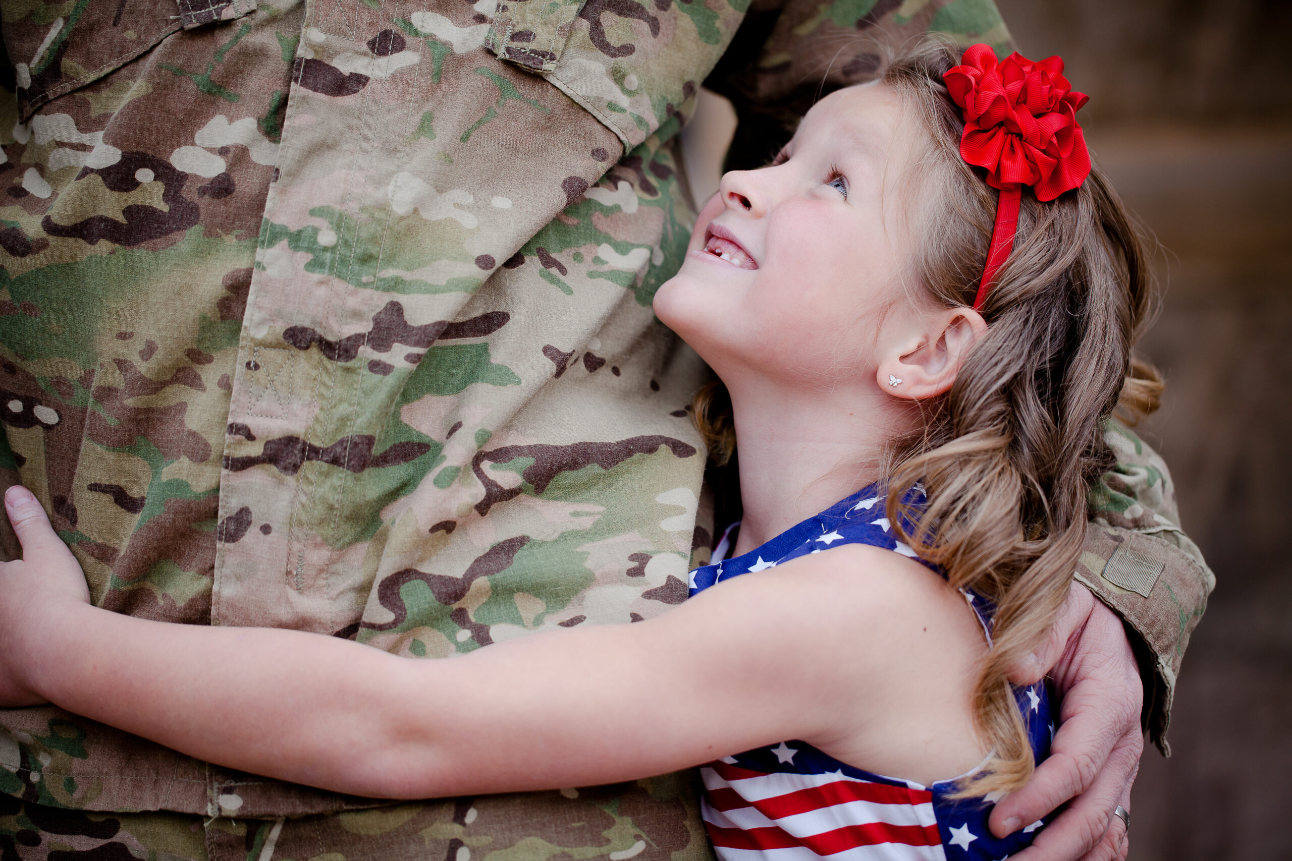 Military child hugging service member parent in uniform