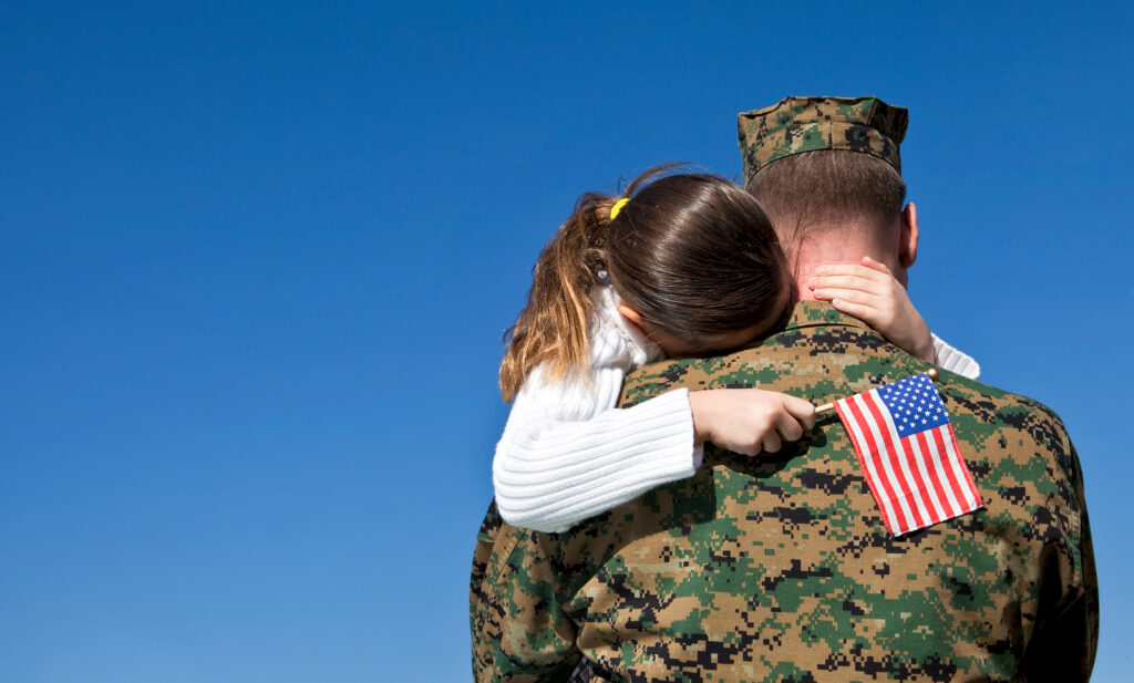 Military Father Hugging His Daughter With An American Flag