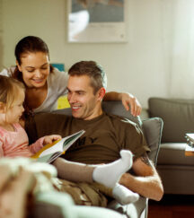 Father reuniting with his wife and daughter at home after deployment